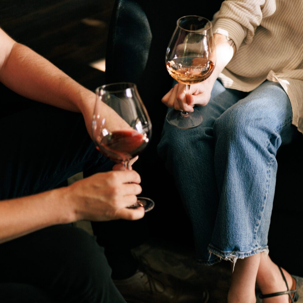 Two people sitting with glasses of wine at the Domaine Lumineux tasting room.