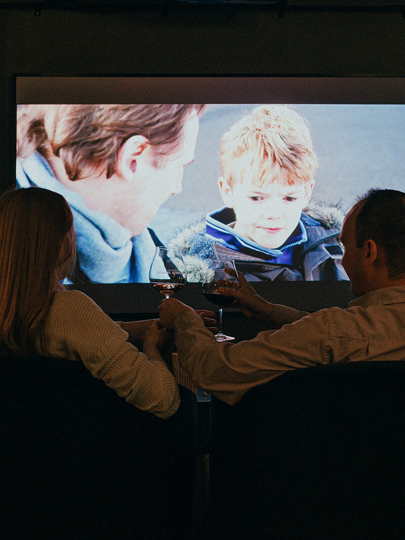 People watching a movie at the domaine Lumineux tasting room.